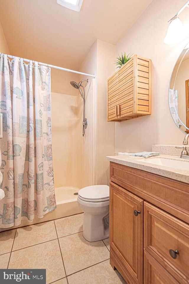 bathroom with tile patterned floors, toilet, vanity, and a shower with curtain