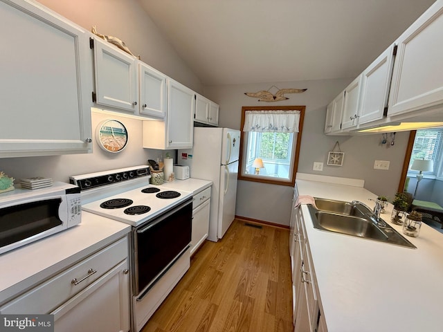 kitchen with light countertops, vaulted ceiling, light wood-style floors, white appliances, and a sink