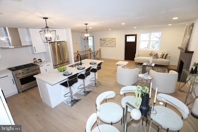 dining room with light wood-type flooring, an inviting chandelier, baseboards, and recessed lighting