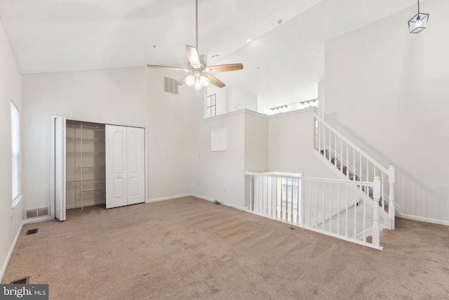 interior space featuring visible vents, high vaulted ceiling, and carpet flooring