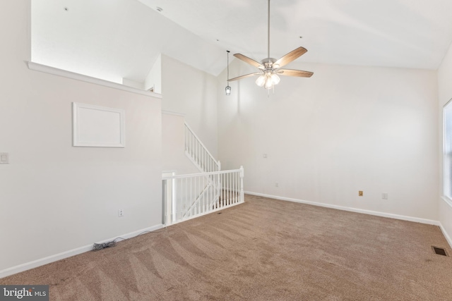 carpeted empty room featuring visible vents, ceiling fan, high vaulted ceiling, and baseboards