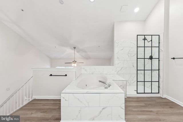 bathroom with a bath, wood finished floors, baseboards, and a walk in shower