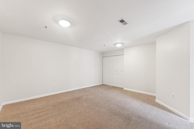 unfurnished room with visible vents, baseboards, and carpet