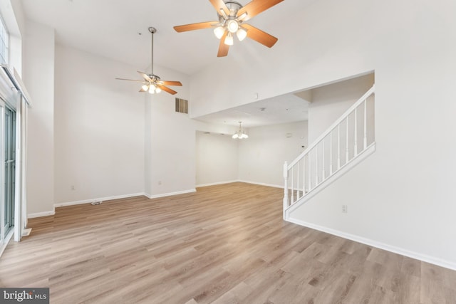 unfurnished living room with light wood-type flooring, visible vents, and stairs