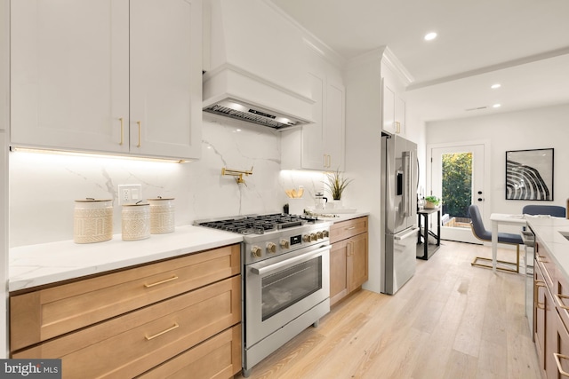 kitchen with tasteful backsplash, recessed lighting, custom range hood, light wood-style flooring, and appliances with stainless steel finishes