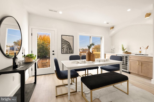 dining room featuring beverage cooler, light wood-style flooring, and recessed lighting