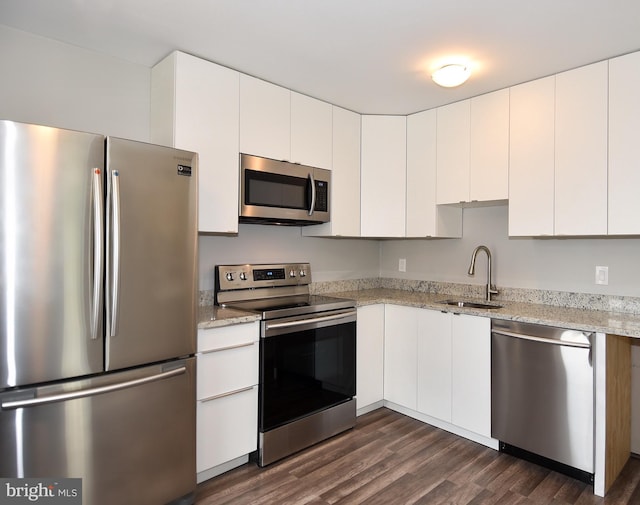 kitchen with white cabinets, appliances with stainless steel finishes, dark wood-type flooring, and a sink