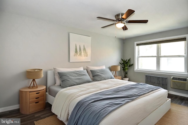 bedroom featuring radiator, baseboards, an AC wall unit, wood finished floors, and a ceiling fan