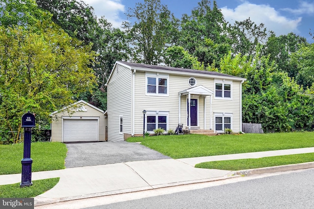 raised ranch with an outbuilding, aphalt driveway, a garage, fence, and a front yard