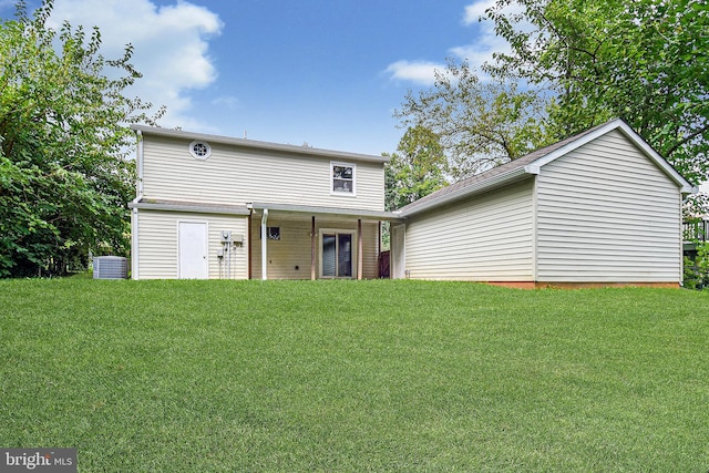 back of house with cooling unit and a yard