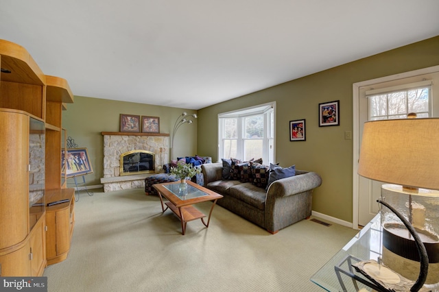 living room featuring a fireplace, visible vents, carpet floors, and baseboards