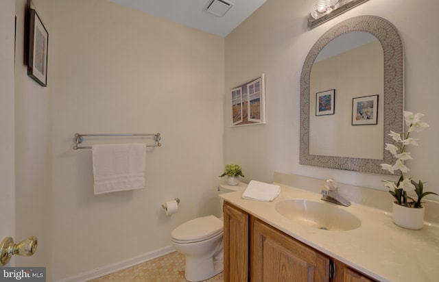 half bath with visible vents, toilet, and vanity