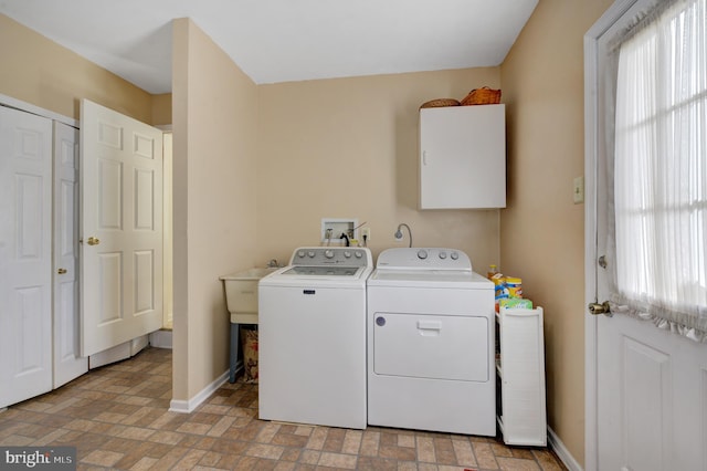 laundry area featuring washer and clothes dryer, laundry area, a wealth of natural light, and baseboards