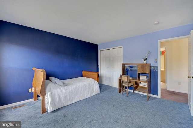 carpeted bedroom featuring baseboards, visible vents, and a closet