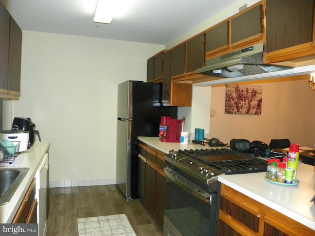 kitchen with range with gas stovetop, dishwasher, dark wood-style floors, light countertops, and under cabinet range hood