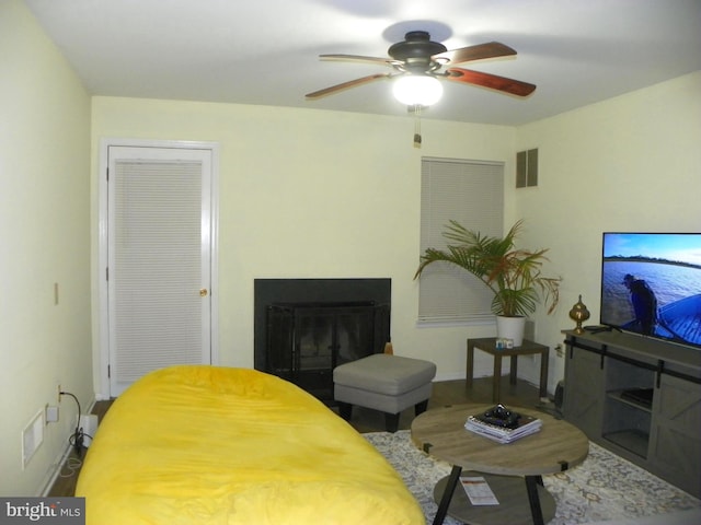 bedroom with a ceiling fan, visible vents, a fireplace, and baseboards