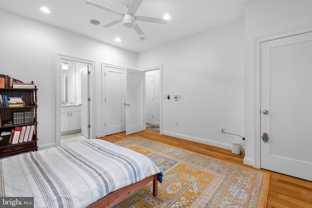 bedroom with light wood finished floors, baseboards, ceiling fan, recessed lighting, and ensuite bath