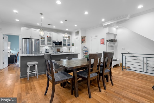 dining area featuring recessed lighting, light wood-style floors, and ornamental molding