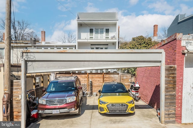 view of vehicle parking with fence