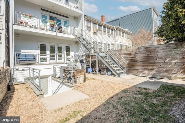 back of house featuring stairs, french doors, and stucco siding