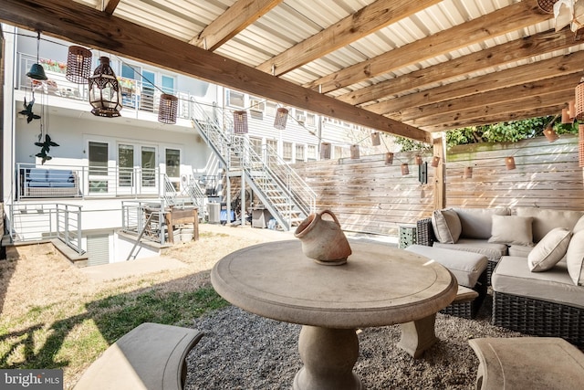 view of patio with french doors, a balcony, stairs, and fence