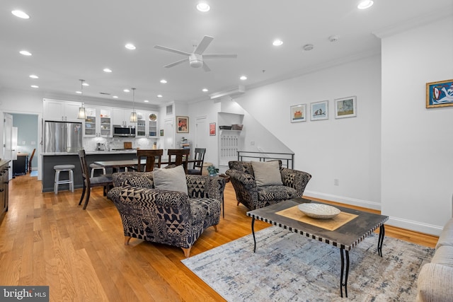 living area with recessed lighting, crown molding, light wood-type flooring, and baseboards