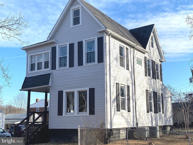 view of side of home featuring fence and cooling unit