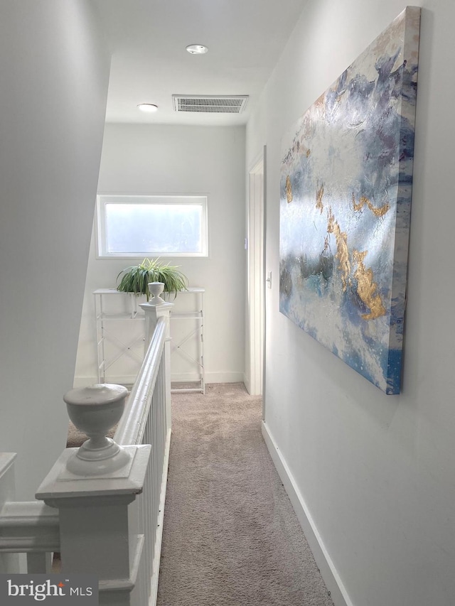 corridor featuring carpet floors, baseboards, and visible vents