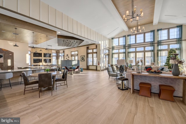 dining room with light wood finished floors, a notable chandelier, high vaulted ceiling, and beam ceiling