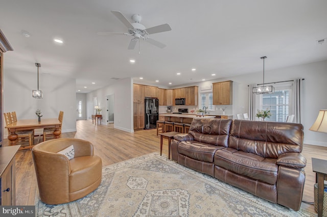 living room featuring visible vents, baseboards, recessed lighting, ceiling fan, and light wood-style floors