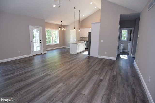 unfurnished living room featuring visible vents, dark wood finished floors, baseboards, and an inviting chandelier