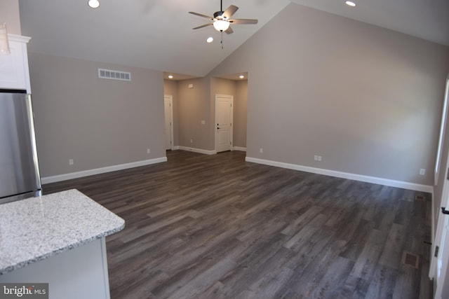 unfurnished living room with ceiling fan, high vaulted ceiling, visible vents, baseboards, and dark wood finished floors