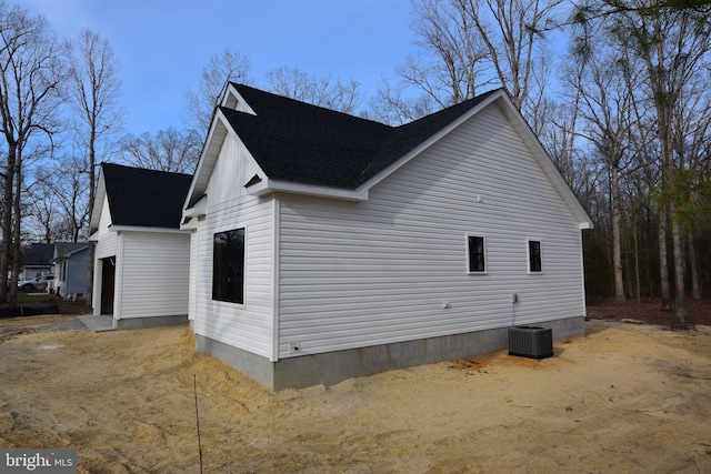 view of property exterior featuring a shingled roof and central AC unit