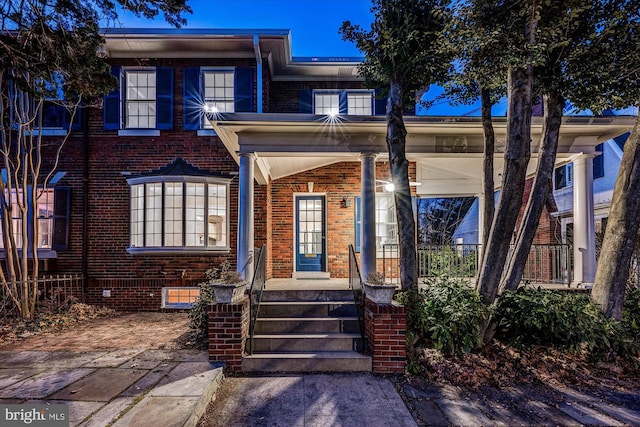 view of front of house with brick siding and a porch