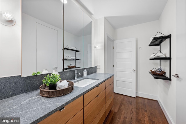 bathroom with vanity, baseboards, and wood finished floors