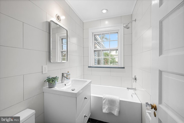 bathroom with toilet, tile walls, and vanity