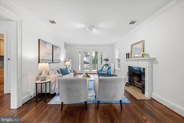 living room featuring french doors, visible vents, a premium fireplace, and wood finished floors