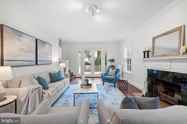 living room featuring stairs, wood finished floors, french doors, and a premium fireplace