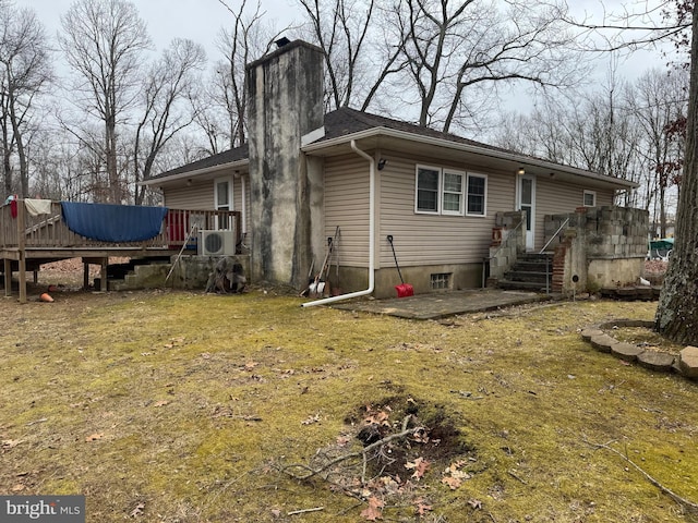 back of property featuring ac unit, a yard, a chimney, a patio area, and a wooden deck