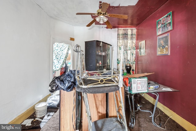 interior space featuring baseboards and a ceiling fan