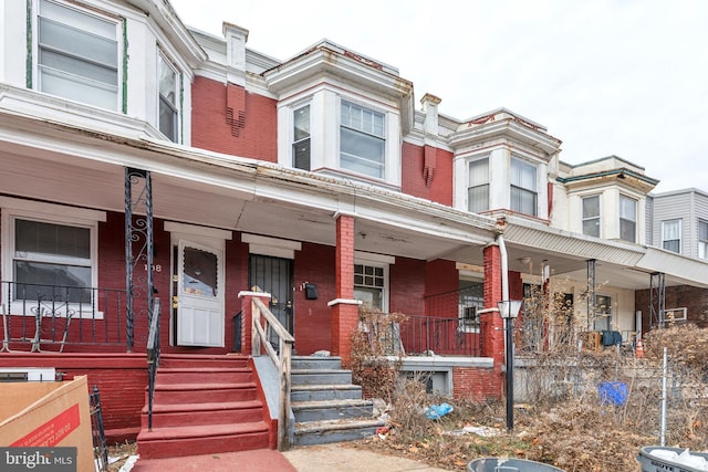 multi unit property with a porch and brick siding