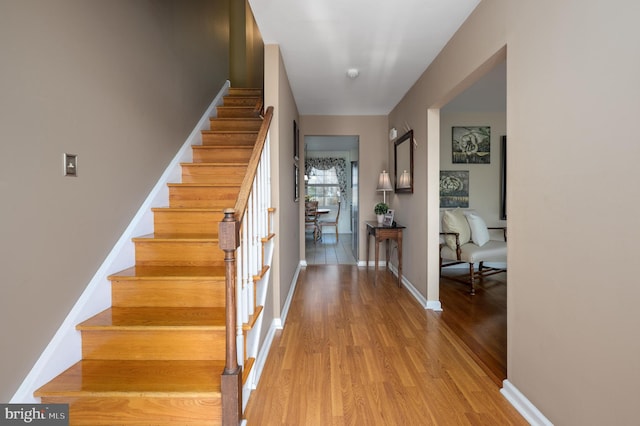 staircase featuring baseboards and wood finished floors