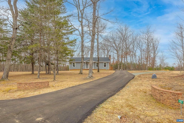 view of front facade with aphalt driveway and a chimney