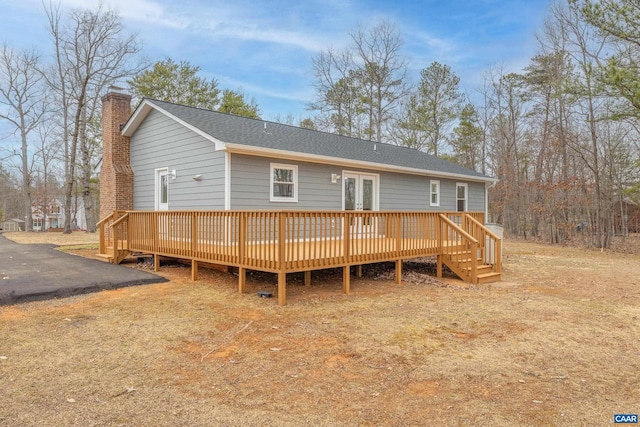 view of front of property featuring french doors, a wooden deck, and a chimney