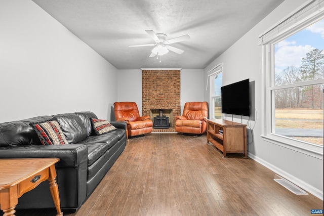 living room featuring visible vents, a healthy amount of sunlight, a ceiling fan, and hardwood / wood-style floors