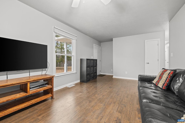 living area featuring visible vents, baseboards, wood finished floors, and a ceiling fan