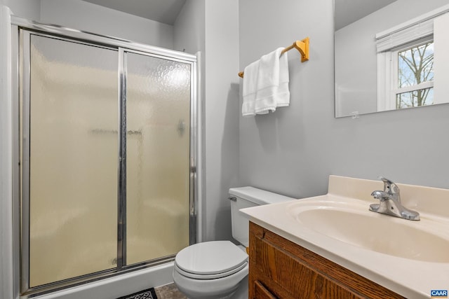 full bathroom with vanity, toilet, and a stall shower