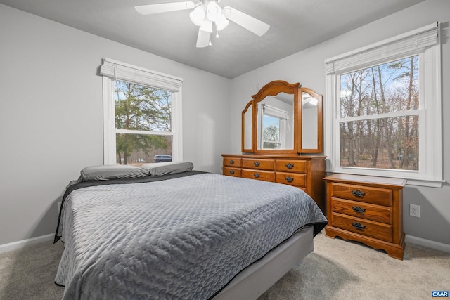 bedroom featuring baseboards, light carpet, and ceiling fan