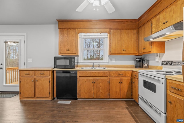 kitchen with black appliances, dark wood-style flooring, under cabinet range hood, and a sink