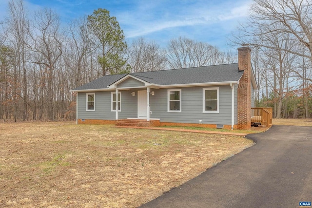 ranch-style house featuring a shingled roof, aphalt driveway, a front yard, a chimney, and crawl space